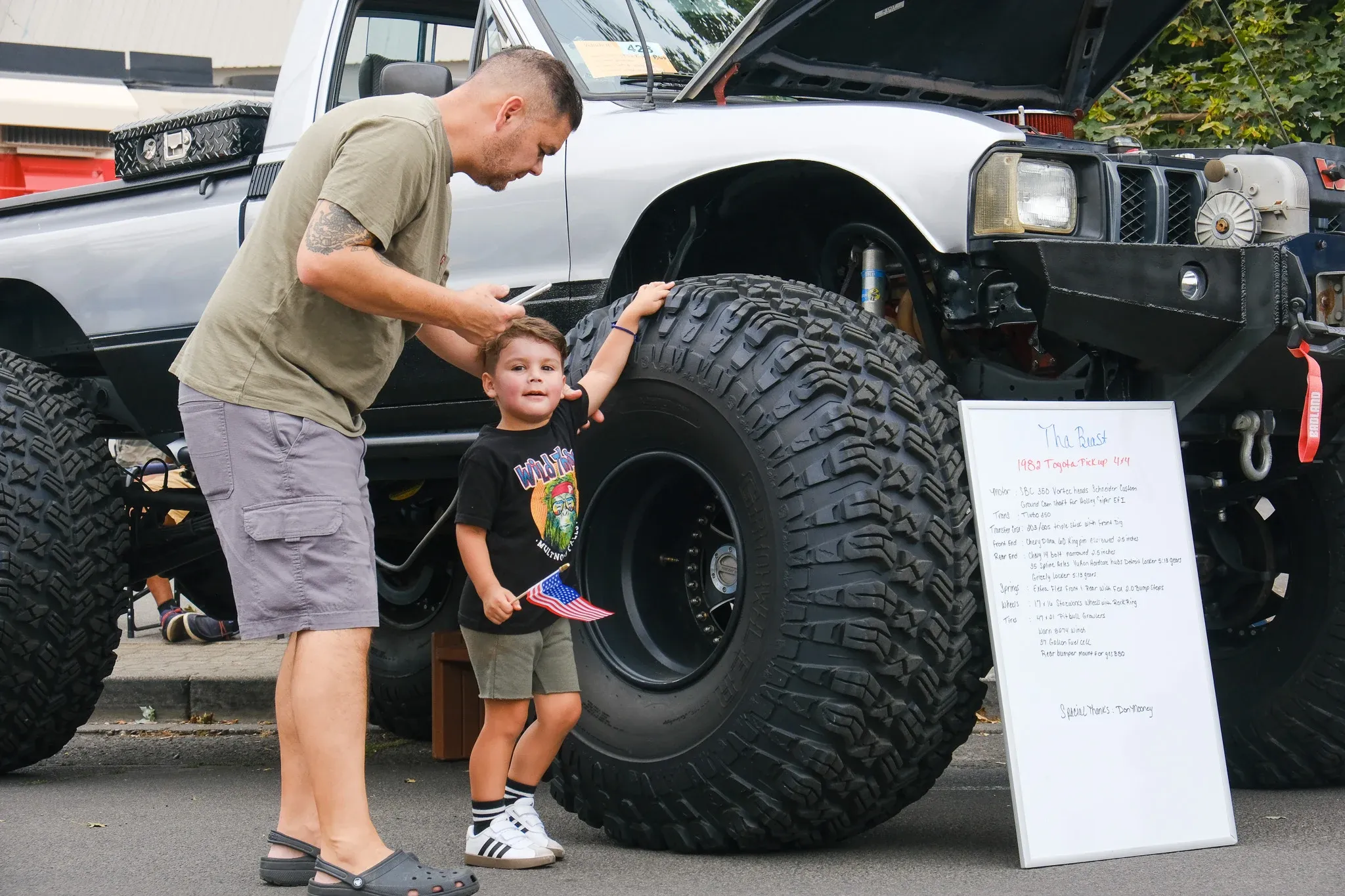 Gerardo Cruz sets his son Leon up for a picture with "Tha Beast," a 1982 Toyota Pickup on 47-inch tires on Saturday, Sept. 6, at Wheelin' Walla Walla.