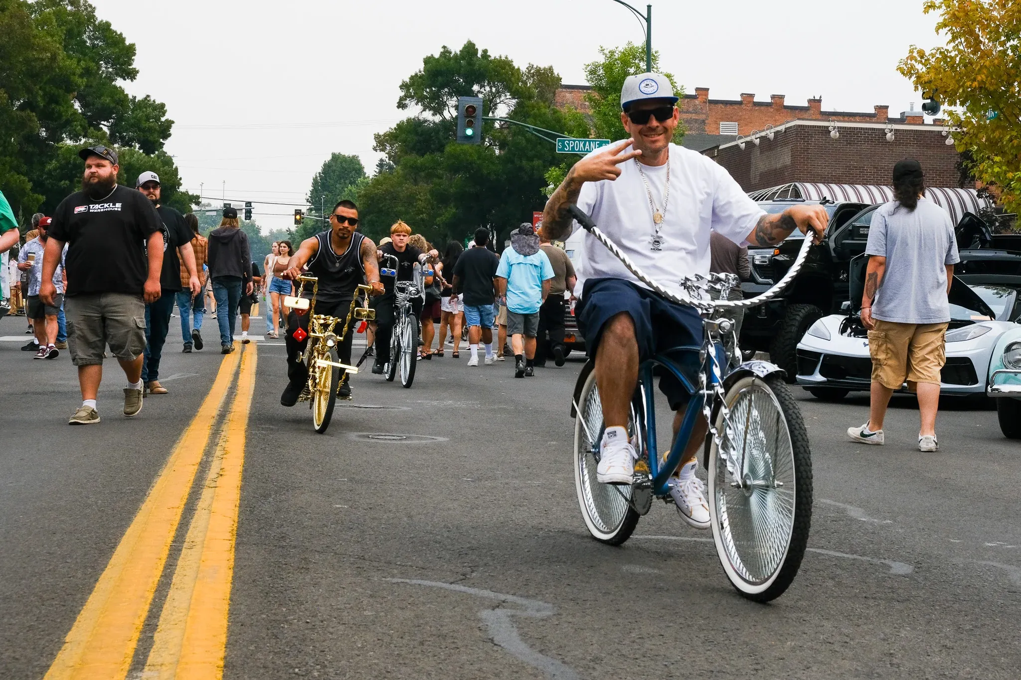 Jason Pastor-O'Neel, president of the Washington State Lowriders Car Club, right, takes point during a cruise along Main Street with Daniel Brito Martinez, left, and Andrew Anderson, center, during Wheelin' Walla Walla. Brito Martinez, who is president of the Washington State Lowriders Bike Club, tricked out the bikes with gold and silver paint and other embellishments.